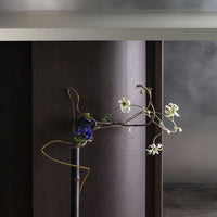 "Elegant purple and white floral arrangement with delicate green accents against a sleek dark background."