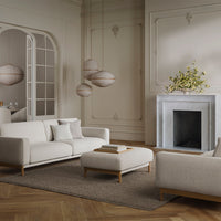 Elegant white sofas with light wood accents, paired with a soft beige rug and subtle patterned decor in a bright room.