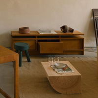 Modern wooden furniture with natural tones, teal and brown accents, and textured surfaces for a minimalist aesthetic.