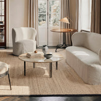 Modern living room with neutral beige and cream furniture, featuring smooth textures and a natural woven rug.