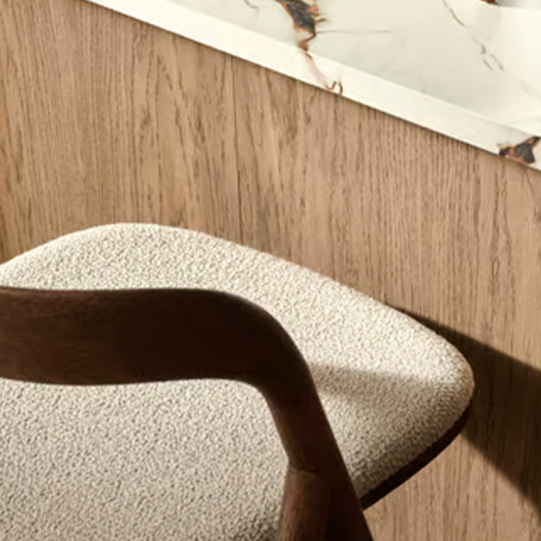 Textured cream upholstery against a warm wood backdrop, complemented by a stylish marble surface.