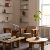 "Soft beige tones with natural wood patterns and green plant accents in a minimalist living room setting."