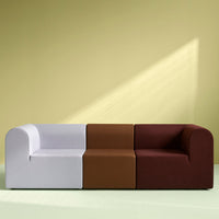 Colorful modular sofa featuring white, brown, and burgundy fabric sections against a soft green backdrop.