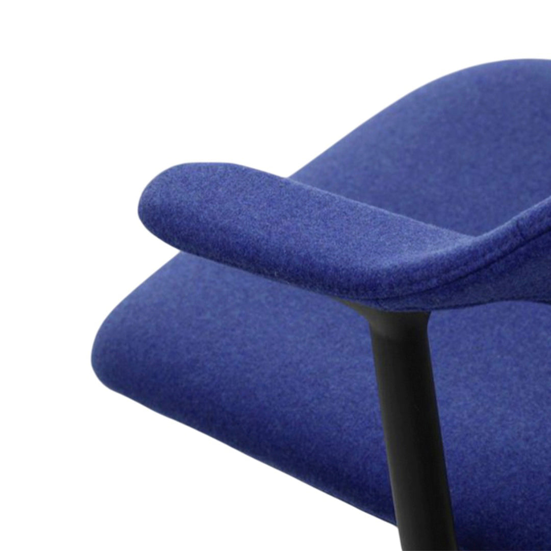 Blue upholstered chair armrest with a sleek black base, featuring a smooth, textured fabric.