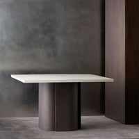 Modern white countertop table with dark wood cylindrical base, set against a textured gray background.