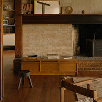 Natural wood tones with a textured brick wall and soft beige patterns, creating a warm, inviting interior atmosphere.