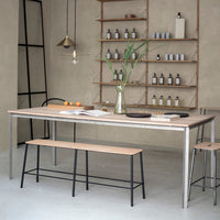 Minimalist wooden dining table with a natural finish, complemented by black metal legs, against a neutral backdrop.