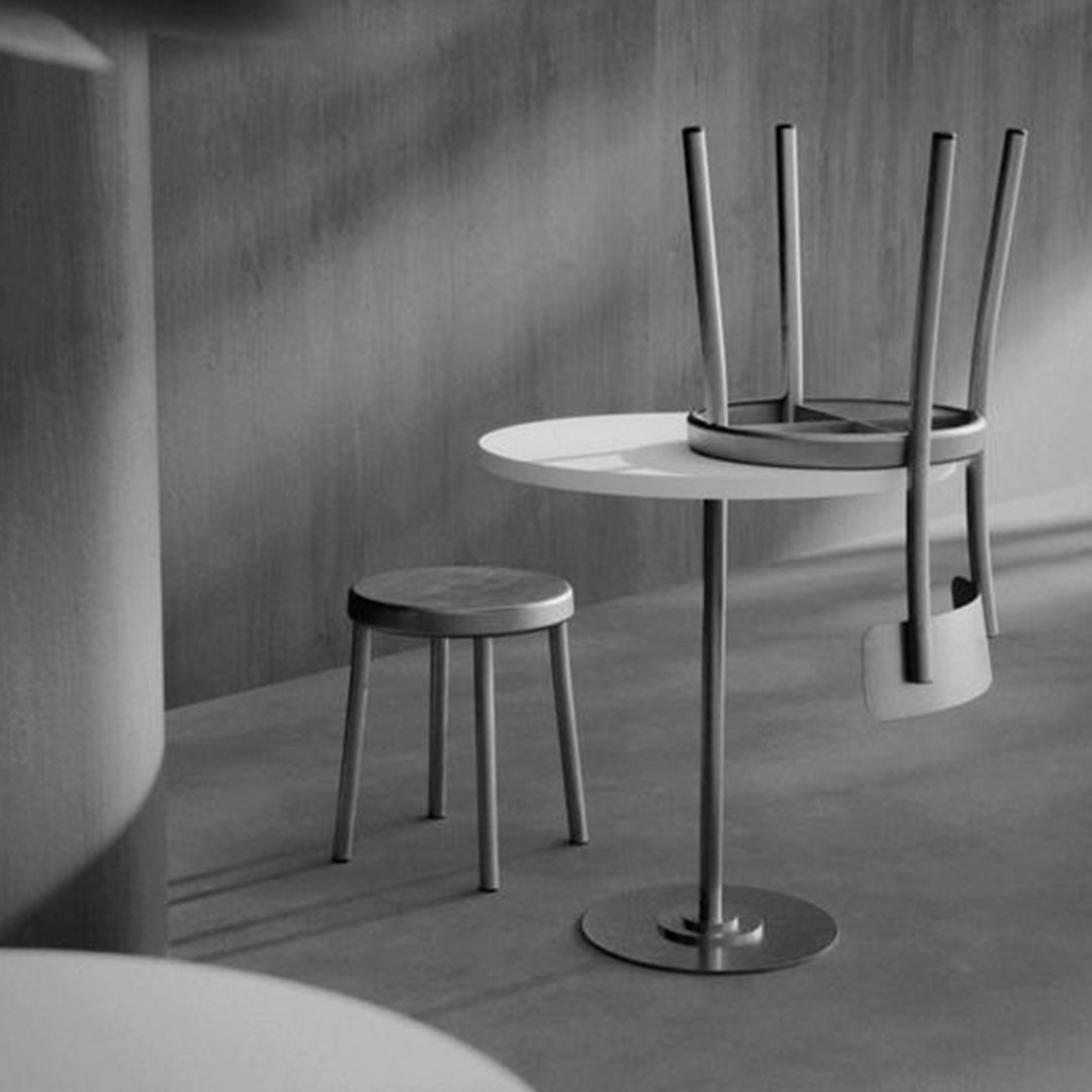 Stylish black and white minimalistic furniture featuring a round table, stools, and sleek, modern lines.