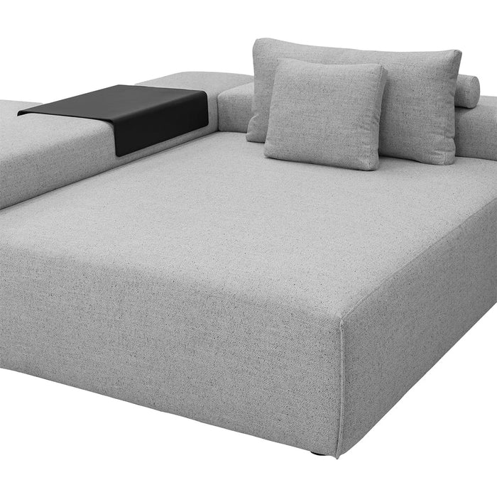 Gray upholstered sofa with textured fabric and a black accent table on one side. Modern, minimalist design.