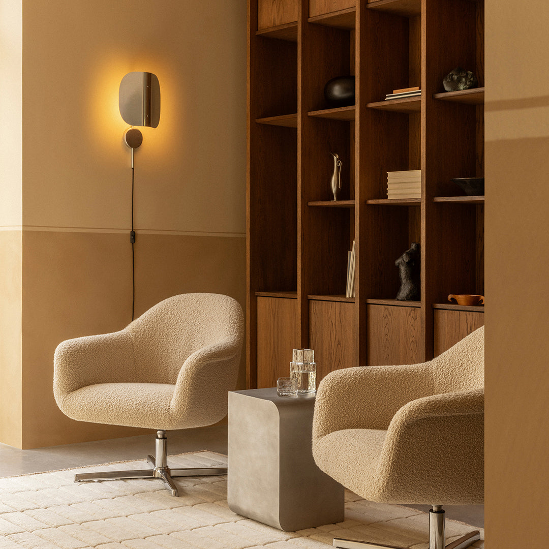 Beige armchairs with soft textures, complemented by warm wood accents and a neutral color palette in a cozy interior setting.