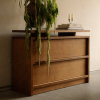 Brown wooden dresser with a smooth finish and clean lines, featuring three horizontal drawers and a stylish top.