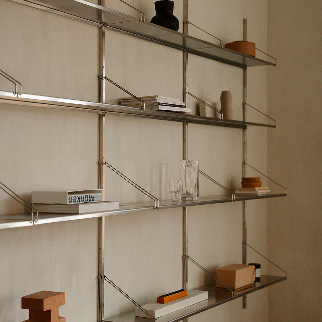 "Modern metal shelving in a soft neutral palette with minimalist wood accents and geometric patterns."