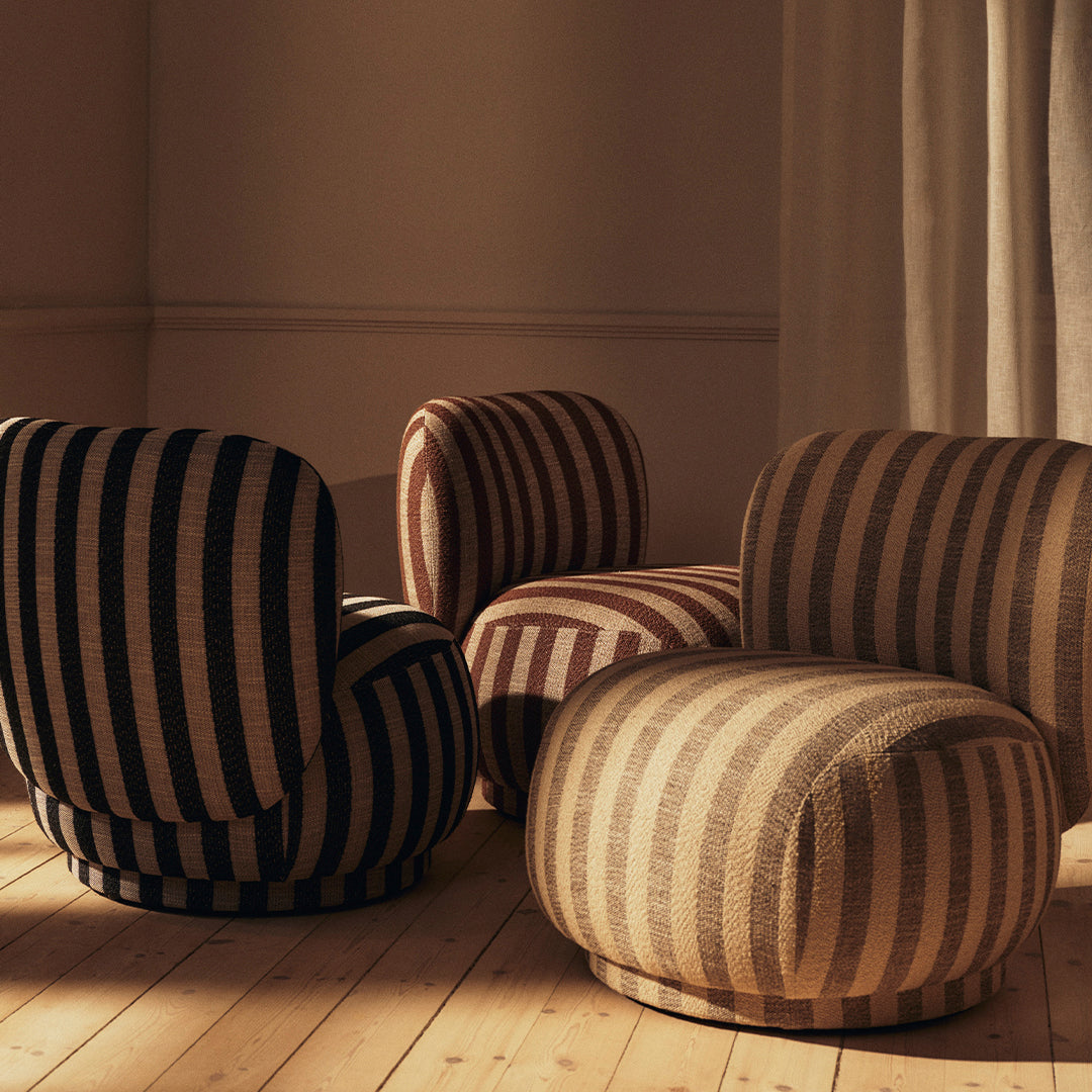 Striped upholstered chairs in black, beige, and brown tones on a wooden floor. Soft, rounded design for modern decor.