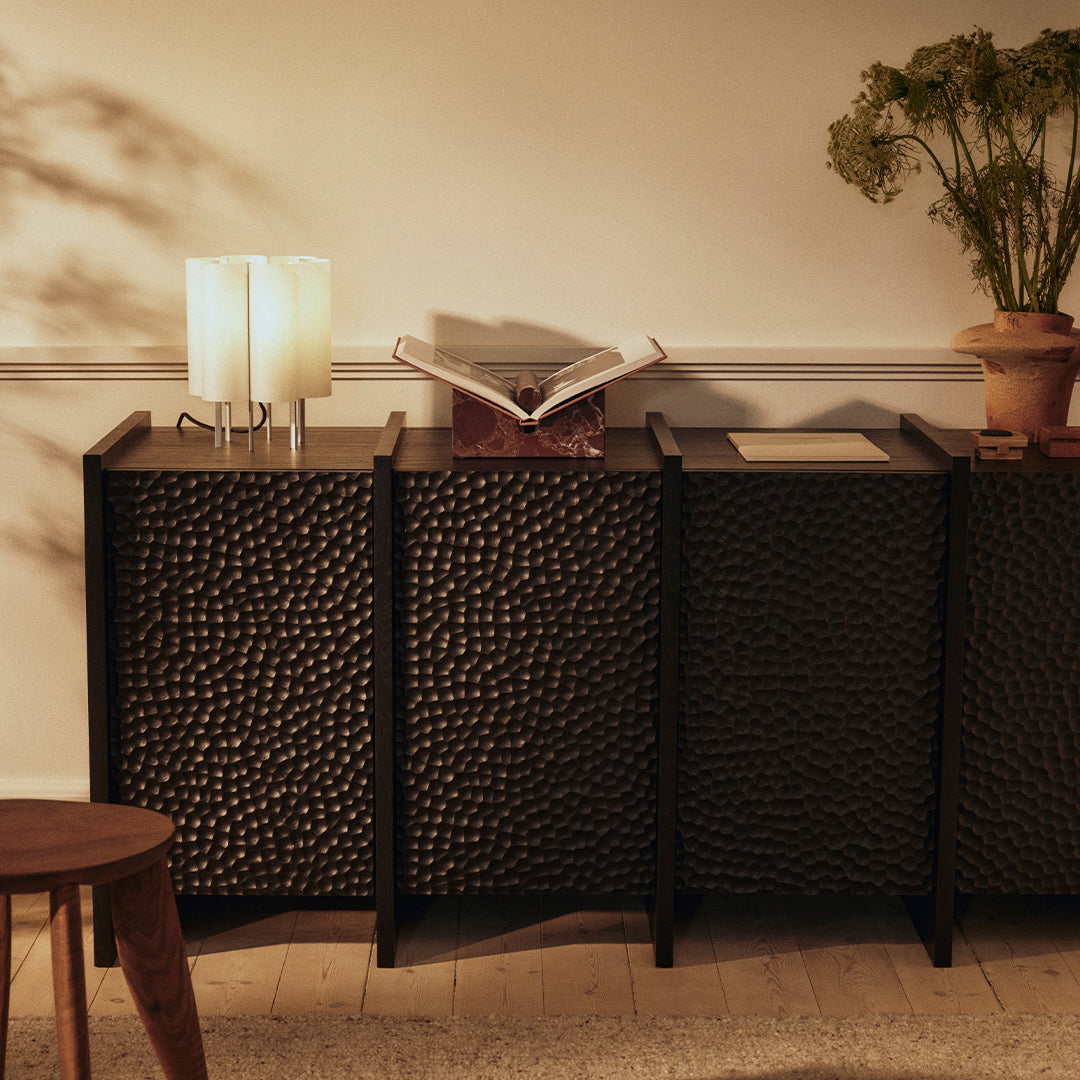 Dark textured cabinet with a unique pebble pattern, complemented by soft beige walls and warm lighting.