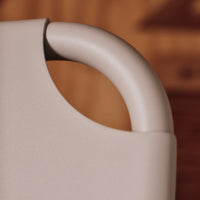 Light beige handle with a smooth, rounded contour against a warm wooden background. Modern minimalist design.