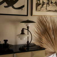 Elegant black and white lamp with layered shades, complemented by neutral decor and soft natural tones.