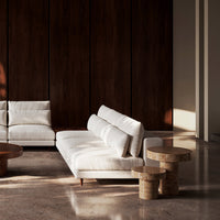 Elegant white sofa with subtle texture, set against rich dark wooden panels and polished stone flooring.