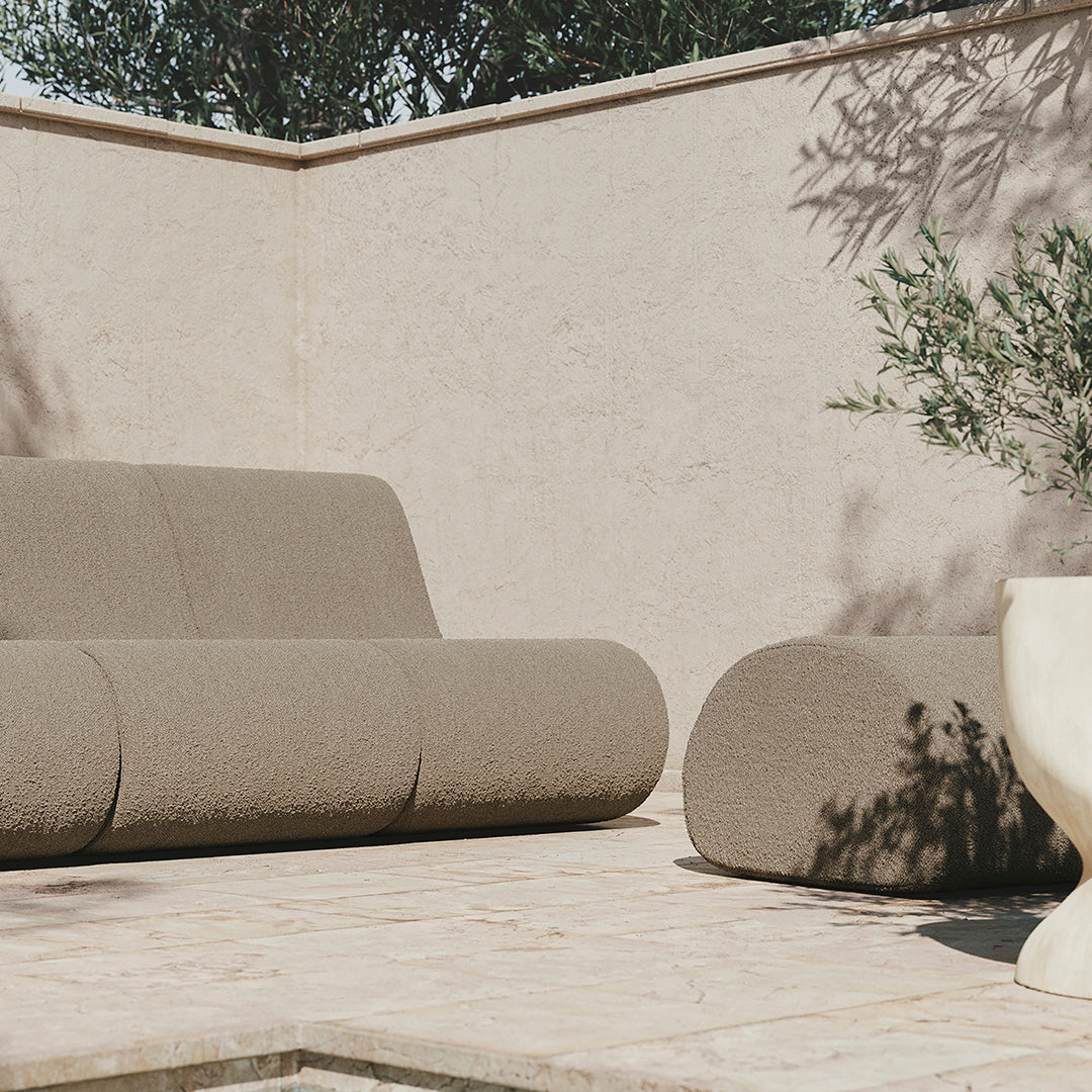 Minimalist outdoor sofa set in earthy beige tones with subtle texture, complementing a neutral background.