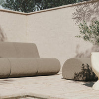 Minimalist outdoor sofa set in earthy beige tones with subtle texture, complementing a neutral background.
