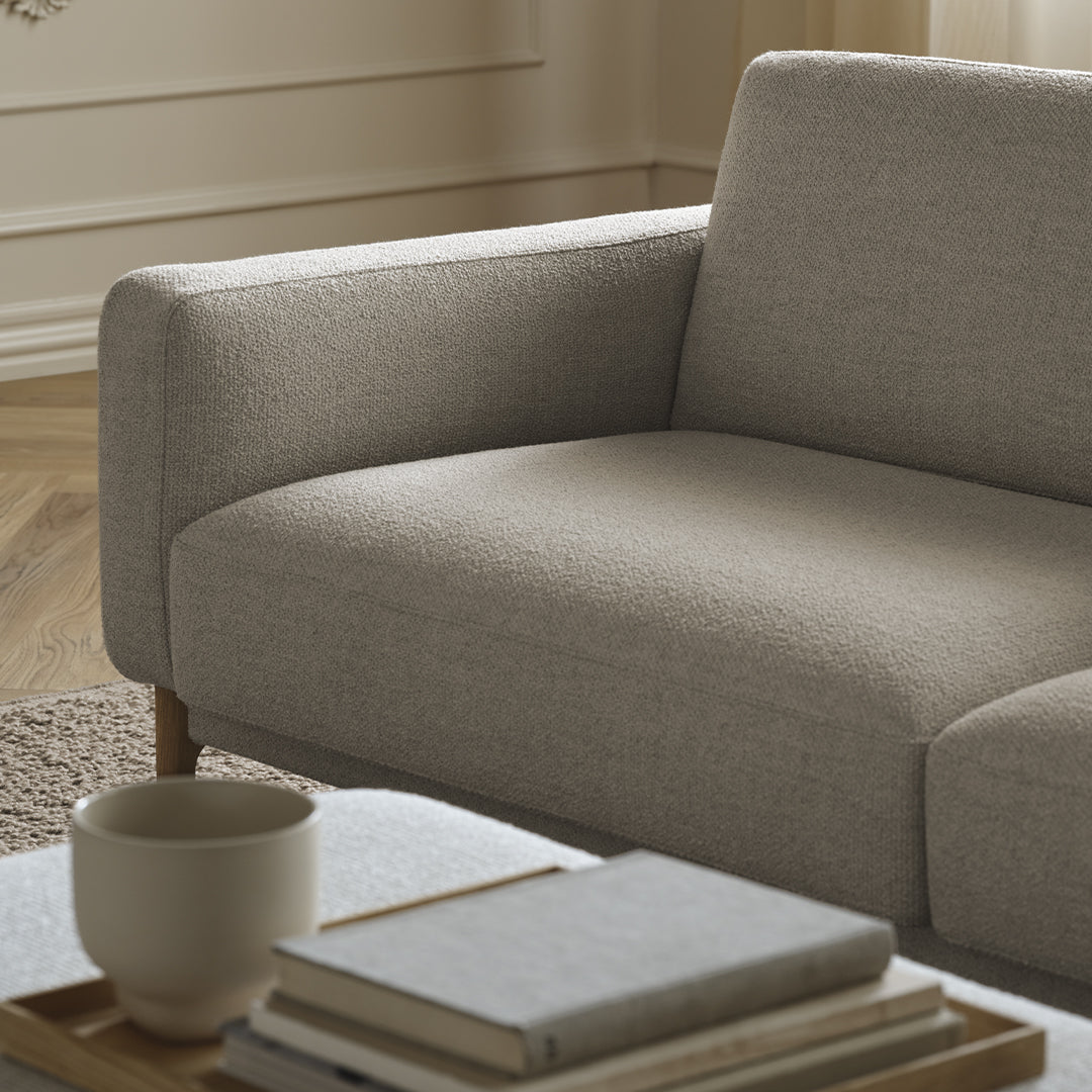 Light gray textured upholstery on a modern sofa with a soft, inviting design and natural wood legs.