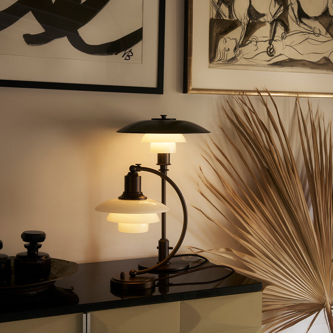 Stylish black and white lamp with glass globe shades, accented by warm light; modern decor with elegant lines.
