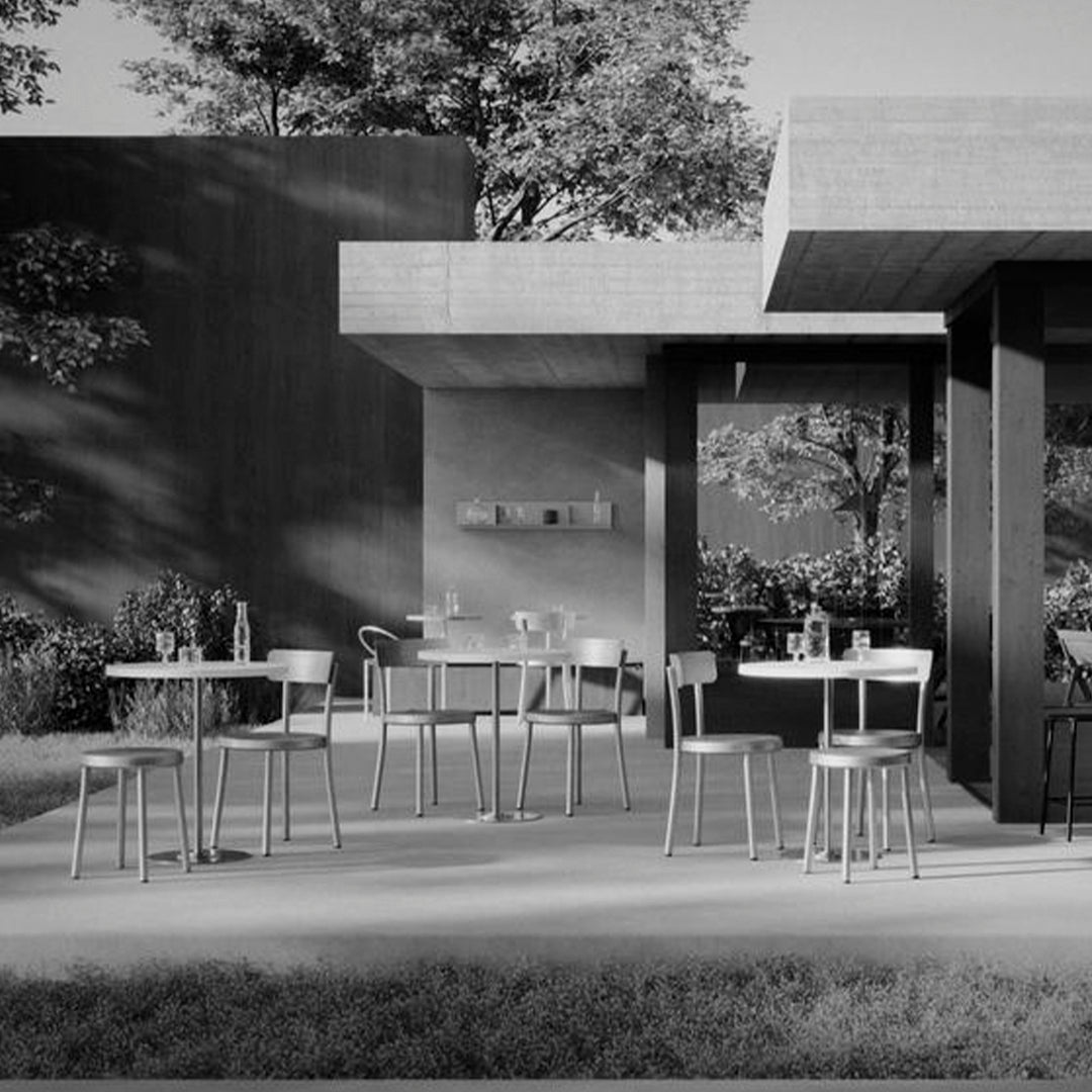 Modern outdoor patio setting with sleek black and gray tones, featuring minimalist furniture and natural greenery.