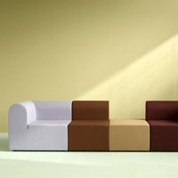 Modern modular sofa featuring soft white, rich brown, warm beige, and deep burgundy fabrics against a pale green backdrop.