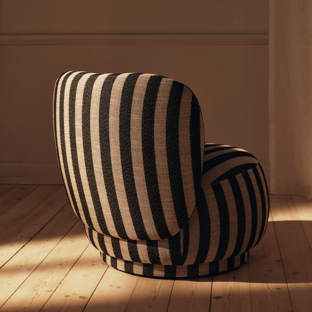 Black and white striped chair with a rounded design, featuring bold vertical patterns and a plush fabric texture.