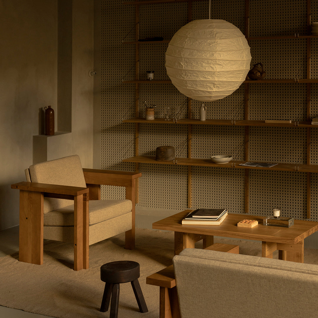 Neutral tones with warm wooden textures and a soft beige backdrop, featuring a round white paper lamp.