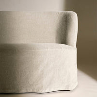 Beige upholstered sofa with a smooth, textured surface and rounded edges, adding a cozy and modern touch.