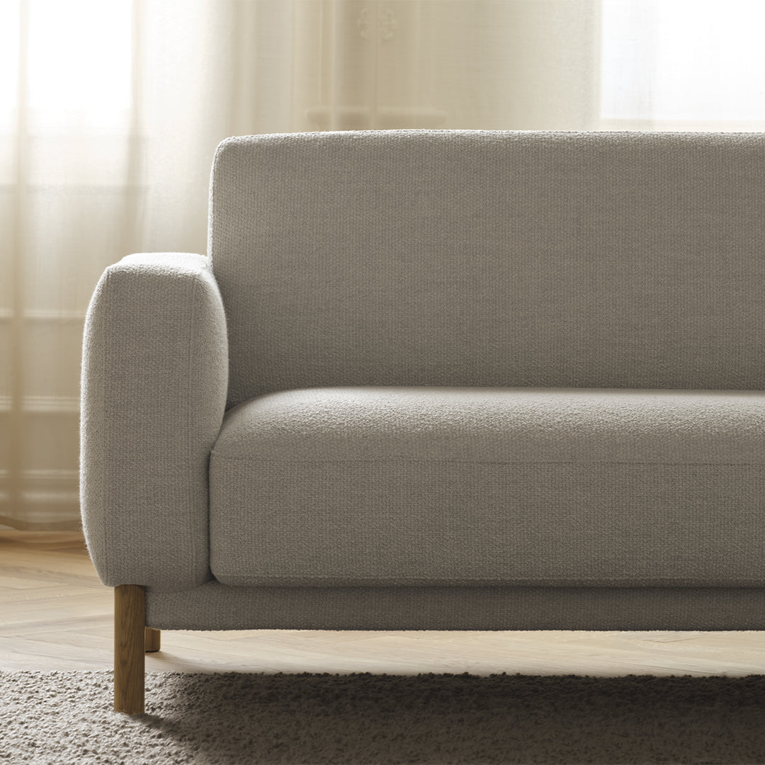 Light gray, textured fabric sofa with minimalist design and natural wood legs, perfect for modern living spaces.