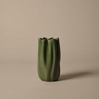Green textured vase with ribbed design, featuring a fluted top against a neutral background. Ideal for modern decor.