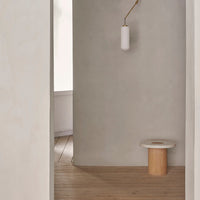 Minimalist room with gray walls, wooden floor, and simple white light fixture, emphasizing natural tones and patterns.