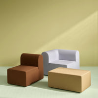 Three modern furniture pieces in brown, light gray, and gold against a soft green and yellow backdrop.