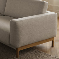 Light beige textured fabric upholstery with a natural wood base, creating a modern and minimalist aesthetic.