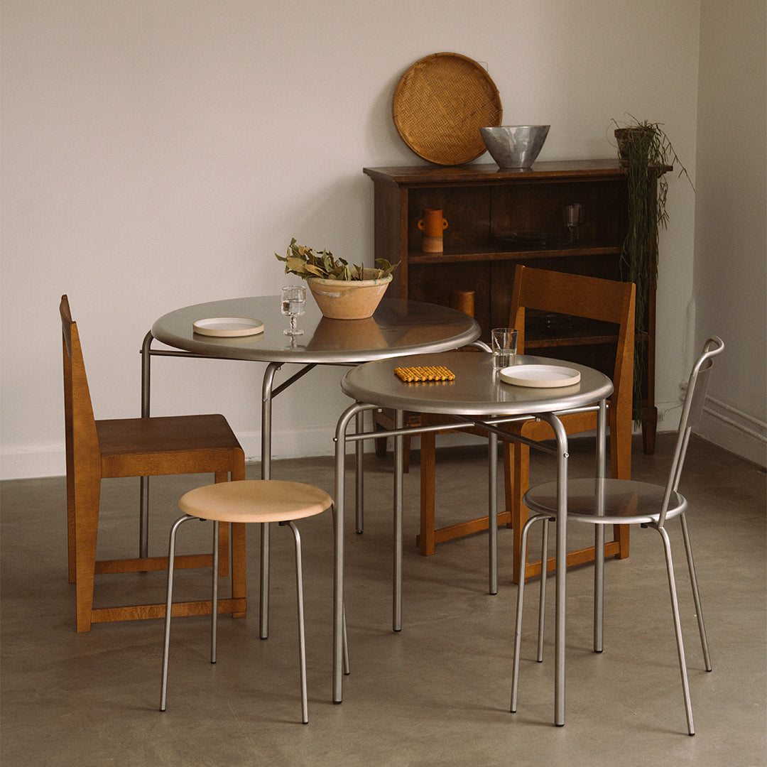 Stylish dining set featuring warm wood tones, metallic accents, and a sleek round table with neutral colors.