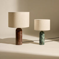 Two stylish lamps featuring a brown marbled base and a green marbled base, both with beige fabric shades.