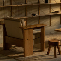 "Modern wooden chair with natural finish and soft beige fabric, surrounded by neutral tones and minimalistic design."