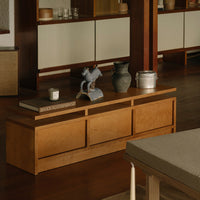 Natural wood-toned coffee table with smooth, minimalist design and subtle grain patterns against a warm, wooden floor.