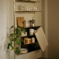 Stylish kitchen shelf showcasing earthy tones, smooth ceramics, and natural wood accents against a neutral backdrop.