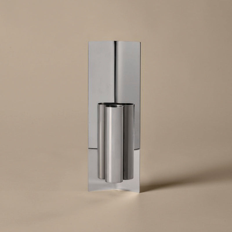 Sleek silver metal with a polished finish, set against a soft beige background. Modern, minimalist design.