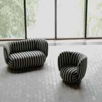 Black and white striped sofa and armchair in modern interior setting.