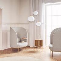 Light gray upholstered chairs with rounded backs, paired with wooden accents, against a soft beige backdrop.