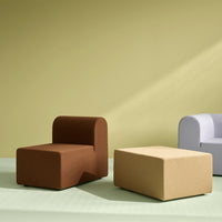 Modern furniture in brown, beige, and light gray against a muted green and yellow background. Stylish and contemporary design.