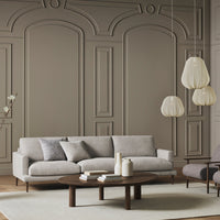 Light gray sofa with matching throw pillows, warm wood accents, and textured beige walls in a modern setting.