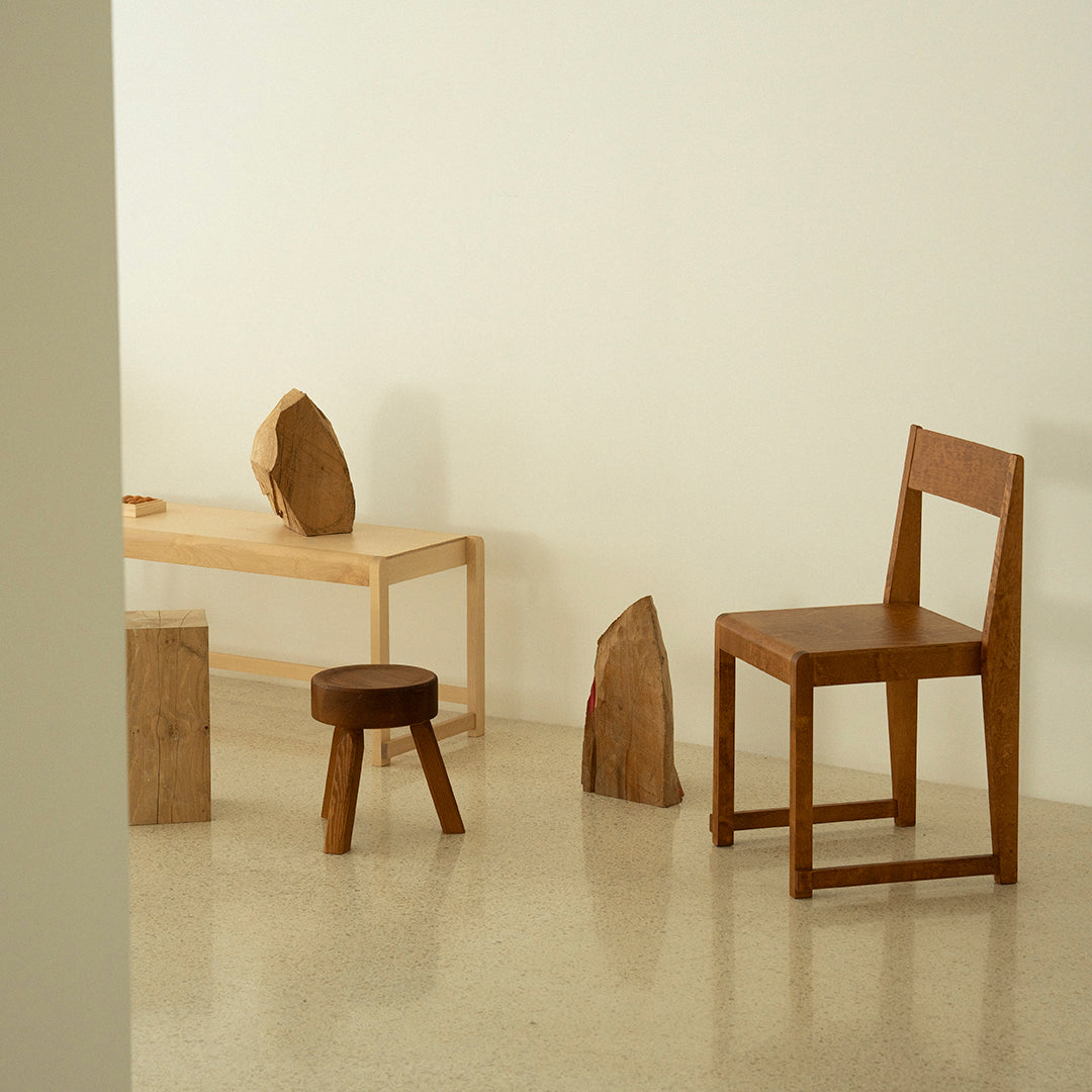 Natural wood furniture in light and dark shades, featuring smooth textures and minimalist design elements.