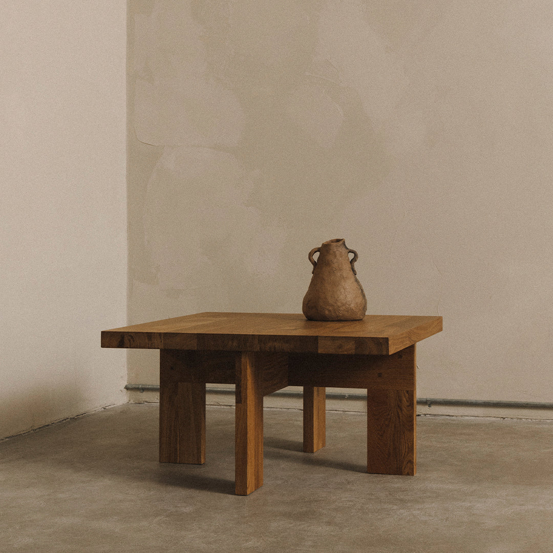 "Natural wood coffee table with a minimalist design, featuring a warm, earthy tone and smooth finish on a neutral background."