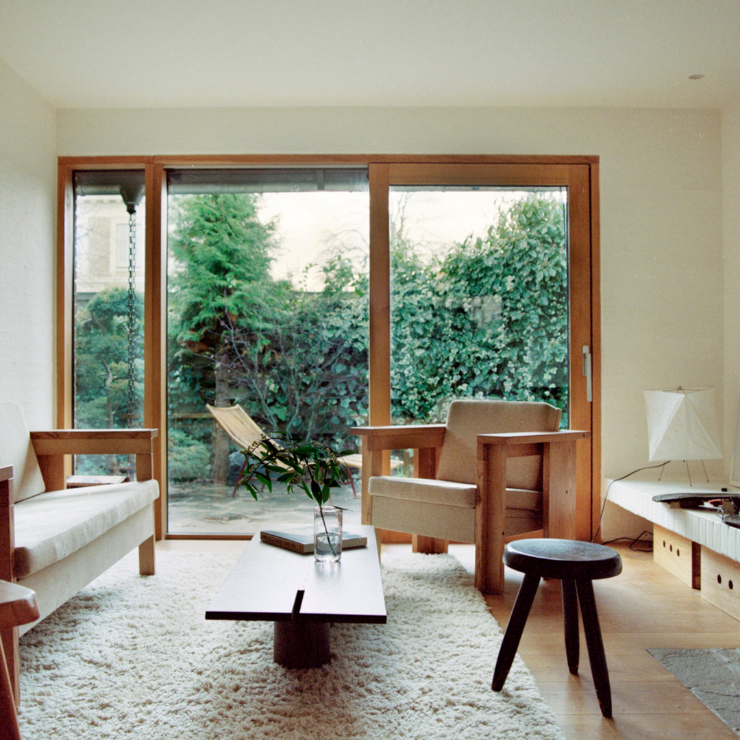 "Modern living room with neutral tones, natural wood accents, and a soft, textured rug inviting a cozy atmosphere."