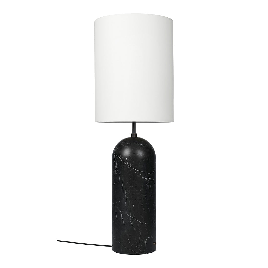 Black marble lamp base with white cylindrical shade; modern design with smooth textures and elegant color contrast.