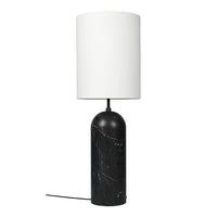 Black marble lamp base with white cylindrical shade; modern design with smooth textures and elegant color contrast.